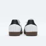 adidas Samba OG 白黑配色雙鞋後跟展示，黑色後跟飾片與焦糖橡膠底